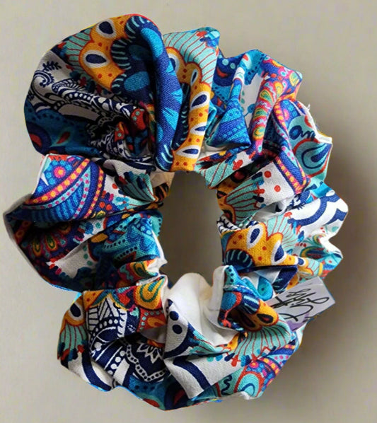 Scrunchie: two tone  front multi-colored blue/yellow/red patterned: back is white hand-crafted , so many uses, hair scrunchie or wristlet.