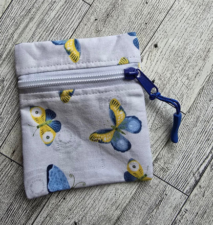 Small:  White Front Zip :  white with blue and yellow butterflies: great size for credit cards, coins, ear buds, folded money, ChapSticks :  Great for tagging to keys