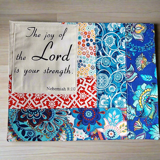 beautiful quilted snack mat/mug rug in  patterned primary colors.  Scripture on this mat is: The Joy of The Lord your strength. Nehemiah 8:10